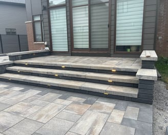 a patio with a brick patio and steps leading up to a patio