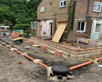 Groundwork contractor installing drainage system