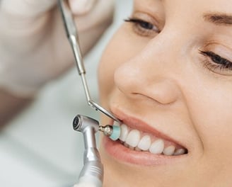 a woman is smiling for teeth cleaning
