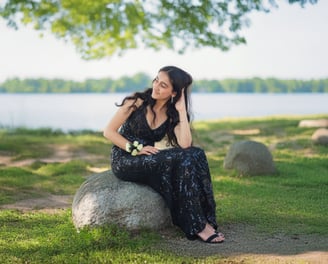 Girl's portrait on a rock near the lake on a sunny day
