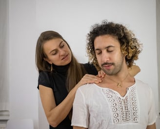 a woman massaging mans shoulders