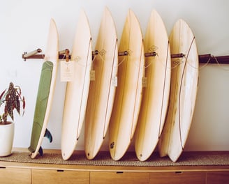 A collection of handmade balsa surfboards neatly displayed on a wooden rack