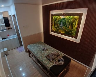 a bed with a bench and a painting on the wall