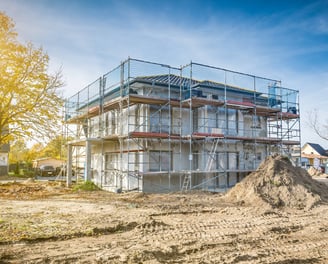 Sanierungsprojekt mit Baugerüst an einem mehrstöckigen Gebäude auf einer Baustelle bei Tageslicht
