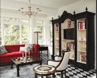 a living room with a red couch and a black and white checkered rug