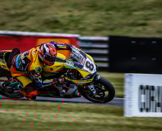 Motociclista che piega in curva con moto gialla e nera e numero 8 in pista