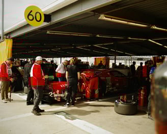 Macchina ferrari rossa nei box meccanici