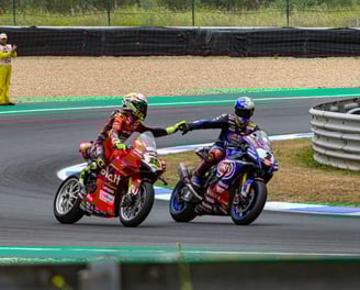 due motociclisti che si danno la mano, moto rosa e blu
