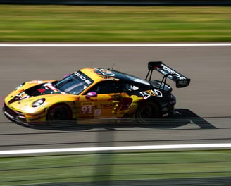 Porsche 911 gt3 gialla e nere durante gara in pista