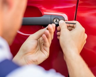 a man is fixing a keychaik on a red car