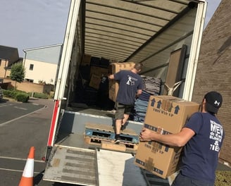 a man and woman loading boxes into a truck