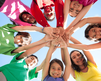 a group of people standing in a circle with their hands together