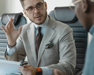a man in a suit and tie is sitting at a table