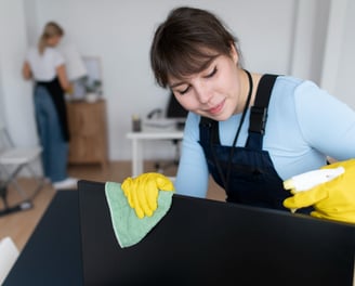 a woman cleaning a laptop computer