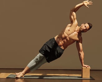 a man doing a yoga pose on a yoga mat