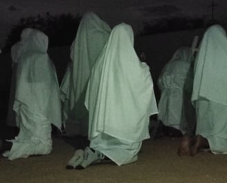 Penitentes encapuzados caminhando à noite, em ritual de fé na comunidade quilombola de São Tomé