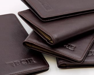 a group of four leather wallets with the word's name on it