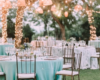 An outdoor wedding venue with light blue table cloths