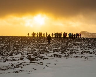 a group of people standing on a snowy field in the Faroe Islands