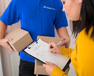 a man and woman holding boxes and a clipboard