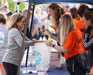a photo of a runner completing their packet pickup before a race