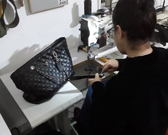 artesã costurando uma bolsa 