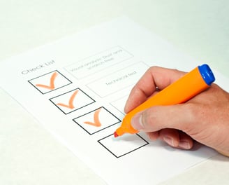 a person holding a pen and writing on a piece of paper