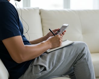 male founder listening to podcast at home