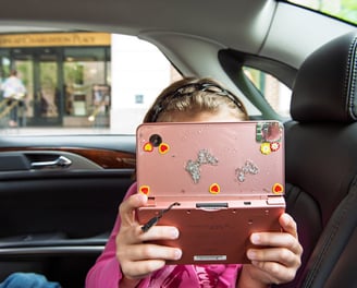 a young girl holding a pink camera in her hands