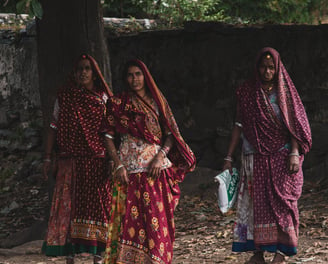 Village women walking to work in traditional Indian attire, rural life during cultural village tours