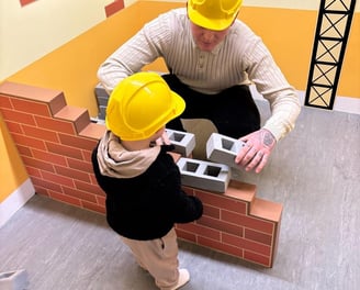 L&G Home Solutions with his young son, wearing builder hats – a family-run business in Lancing