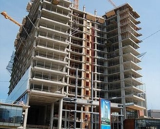 a large building with a crane in the foreground