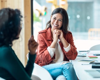 Two women having a positive and engaging conversation in a modern office.