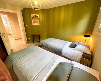 a bedroom with two beds and a lamp