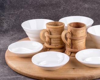 Art of kitchen designer made bowls and water mugs made of bamboo wood placed on a round wood plate