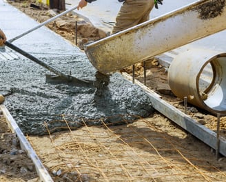 a man is pouring concrete into a concrete slab