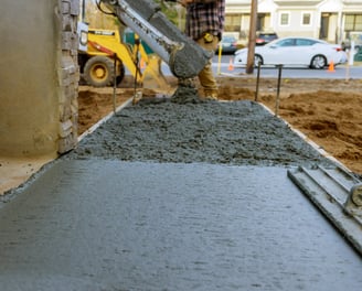 a man is pouring concrete into a concrete slab