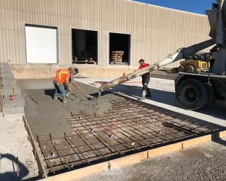 a man is pouring concrete into a concrete slab