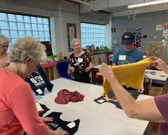 Women laying out a tshirt quilt