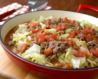 a bowl of cabbage, beef, and tomatoes