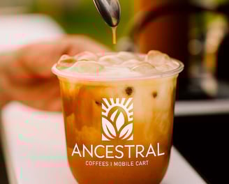 Guest enjoying a latte from a custom-branded coffee cart at a corporate event