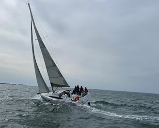 a sailboat with people on it in the ocean