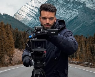 Vidéaste professionnel de Mirai Production lyon en tournage, capturant un paysage montagneux