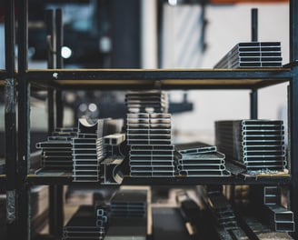 a shelf of metal pipes and pipes in a warehouse