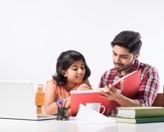 a man and a little girl are sitting at a table