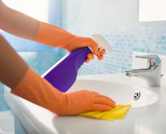 a person in gloves and gloves cleaning a sink