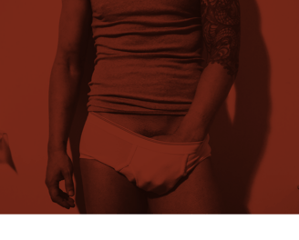 Toronto Gay Escort & Nude Male Massage by Nick Rivera | A red filtered photo of Nick in white briefs