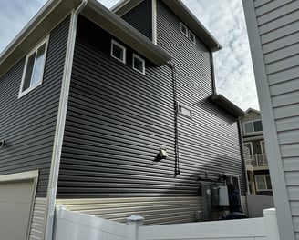 a house with a white fence and vinyl siding