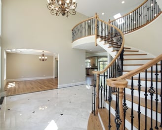 This elegant staircase features rich hardwood treads and handrails with ornate black balusters.