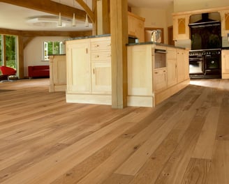 Wide plank hardwood floors in kitchen and living area, natural wood tones with functional elegance.